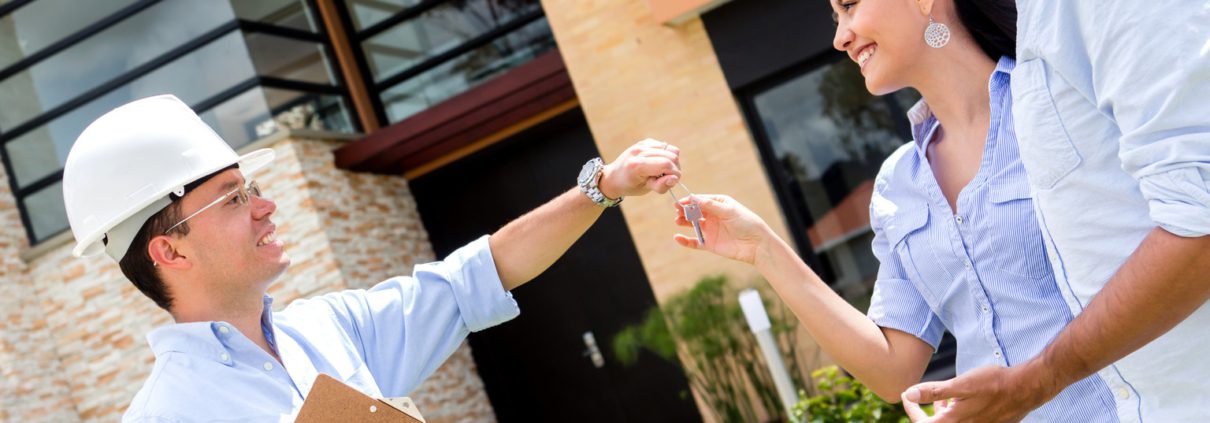 architect handling keys to a couple